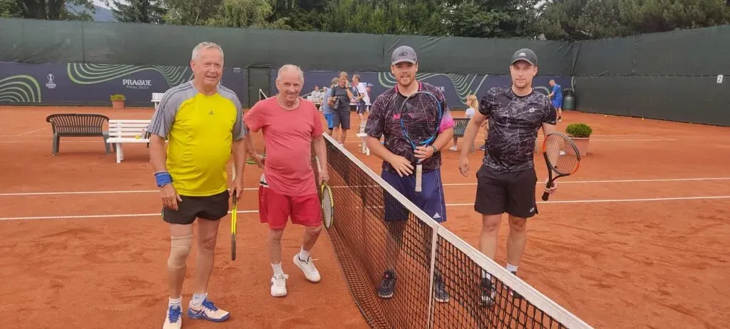 Dva deblové páry se fotografují u sítě po zápase.